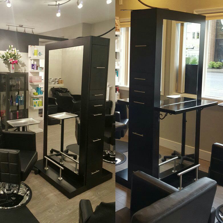 Inside Tonic Salon on Washington Street: styling stations with black cabinetry and mirrors, product shelves, and a window onto the street.